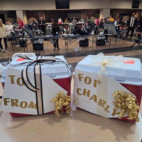 two coolers with a sign that say "to from give like charly" at impactlife blood drive