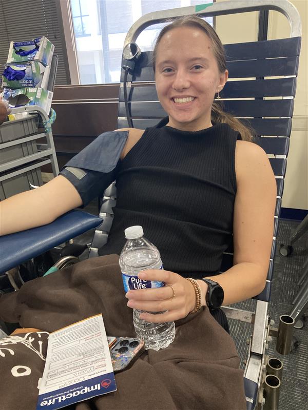 Woman smiling while donating blood at impactlife 