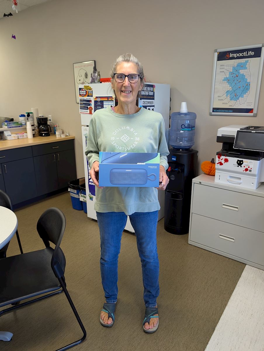 Linda Allaman holding a Bose SoundLink Plus Speaker box at ImpactLife