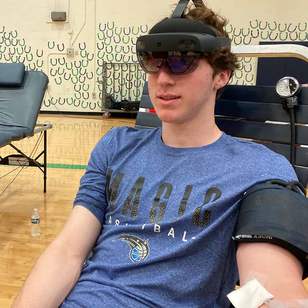 Student using Mixed Reality at a high school blood drive