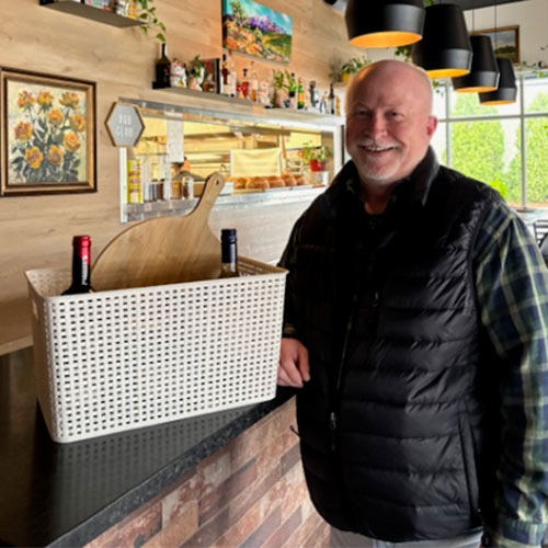 Man standing next to Smash Pizza gift basket.
