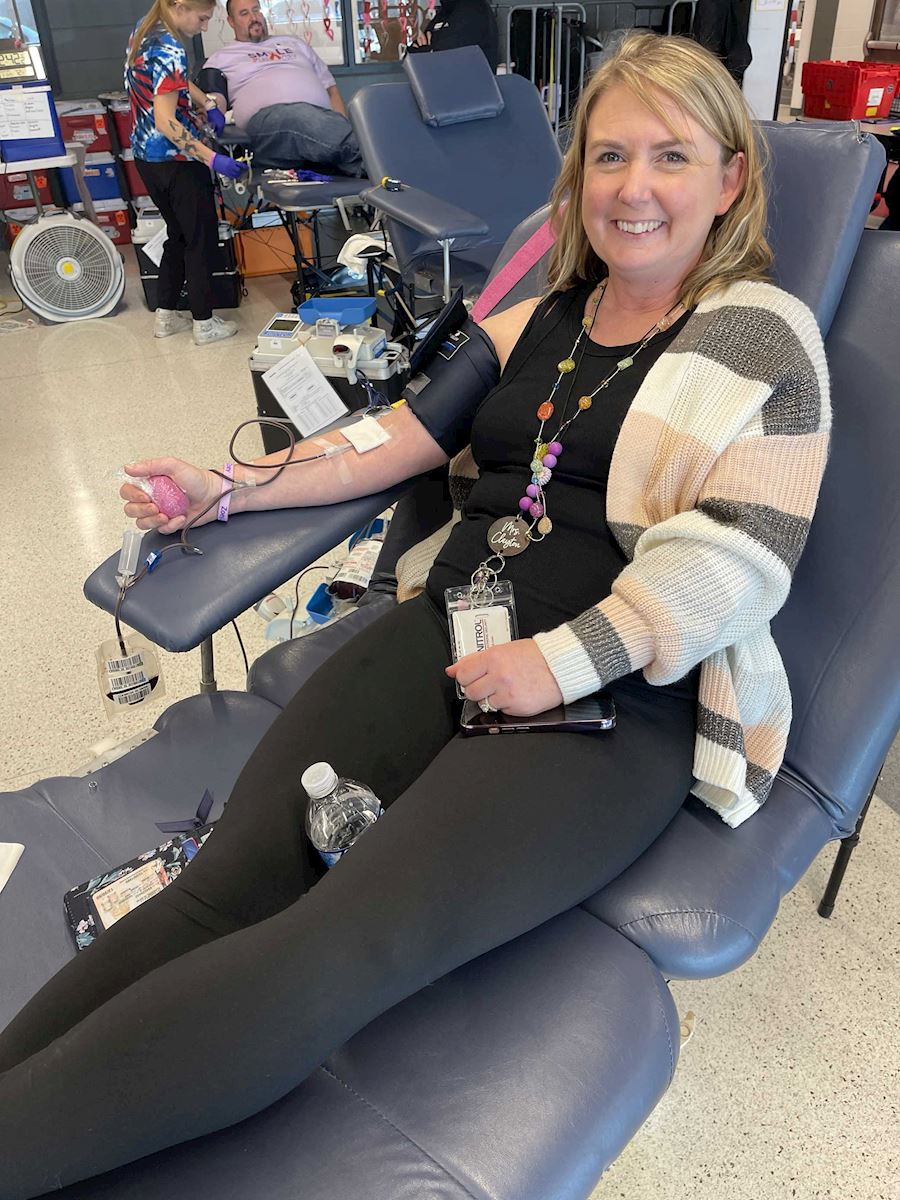Woman wearing a cardigan while donating blood during the ImpactLife drive.