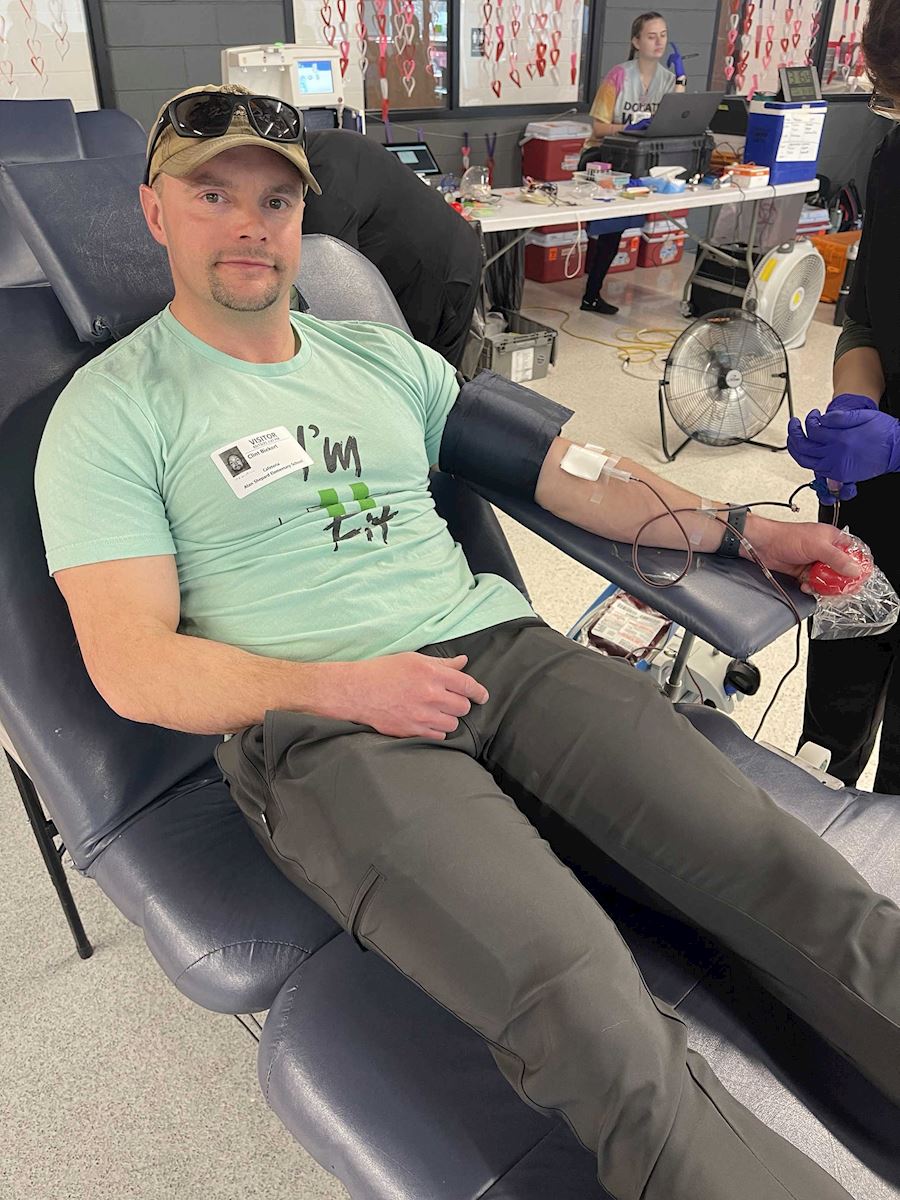 Male donor seated in a reclined chair giving blood at the ImpactLife drive.
