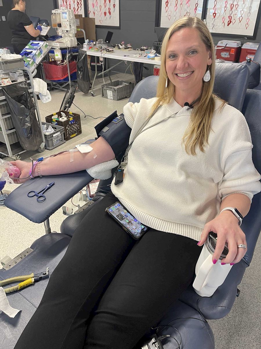 Female donor smiling while donating blood at the ImpactLife event.
