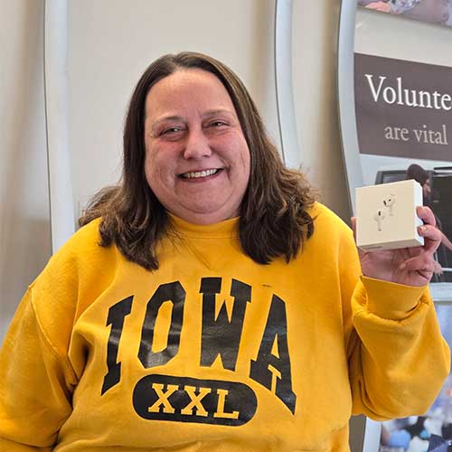 Woman wearing yellow sweatshirt holding box